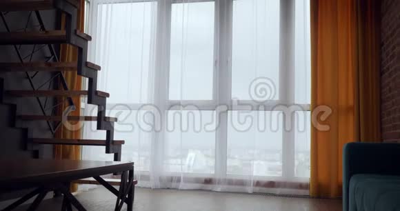 年轻的女人打开窗帘在大的全景窗口附近跳舞视频的预览图
