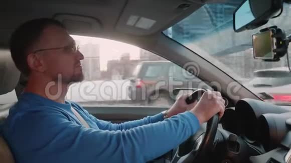 白色司机在汽车方向盘上这是被汽车以同样的方式超越的男人笑了笑笑了笑视频的预览图