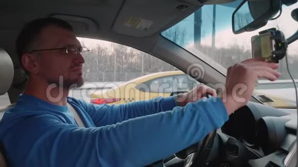 白人在交通堵塞中使用智能手机导航仪来寻找出路下班后回家视频的预览图