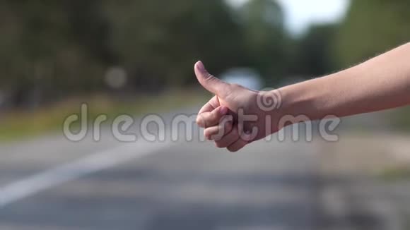 女性手指拇指的特写那个女孩正试图在路上停车4K慢慢视频的预览图