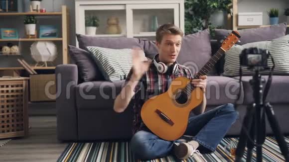 帅哥vlogger正在录制视频供订户教学用吉他演奏乐器和视频的预览图