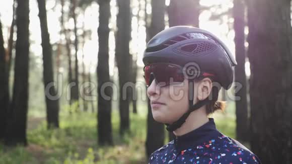 快乐三项运动员女孩戴着黑色头盔戴着自行车眼镜的肖像单车概念视频的预览图