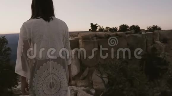 慢镜头跟随快乐兴奋的年轻女子走上令人惊叹的日落大峡谷山景视频的预览图