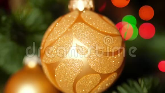 特写4k镜头金色华丽的宝布尔在圣诞树上发光的彩色灯光和花环完美的镜头视频的预览图