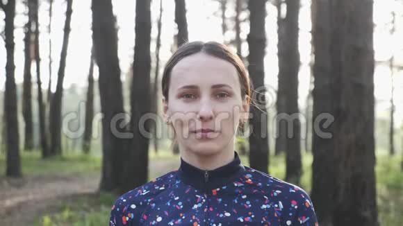 自信的年轻骑自行车的女人戴上头盔看着相机铁人三项概念慢动作视频的预览图