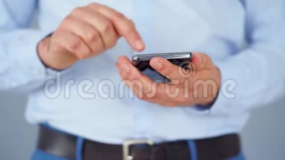 穿着正式服装的男人用智能手机上网特写视频的预览图