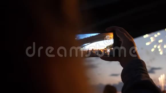女人晚上在夜空的背景下打电话烟火人群4K视频的预览图