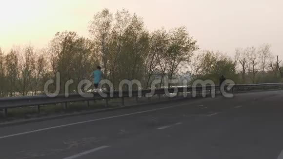 日落时分一个骑自行车的女性骑在镜头前电影自行车的概念慢动作视频的预览图
