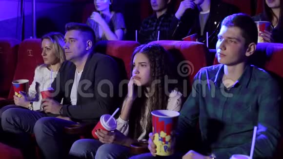 一群年轻人在电影院看一部悲伤的电影女孩在哭视频的预览图