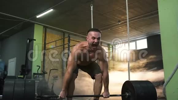 年轻强壮的男人在健身房尖叫和做举重运动视频的预览图