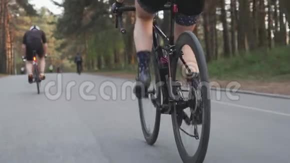 女孩在公园里骑自行车旋转踏板背景是骑自行车和跑步者慢动作视频的预览图