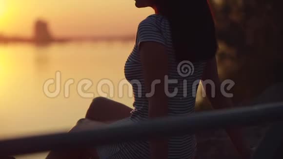 女人坐着放松看日落的剪影视频的预览图