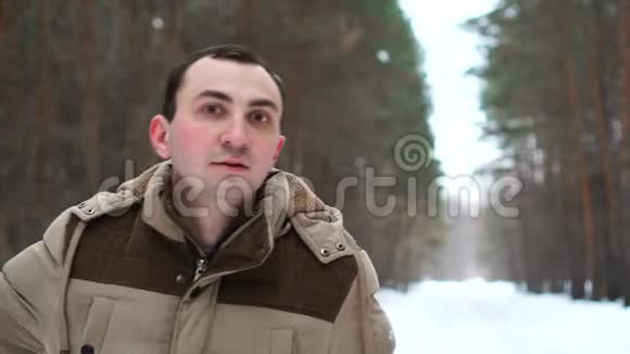 穿夹克的人的肖像在冬天的森林里出现了拇指视频的预览图