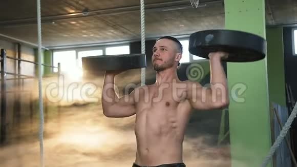 肌肉发达的男人在健身房训练时用体重板锻炼视频的预览图