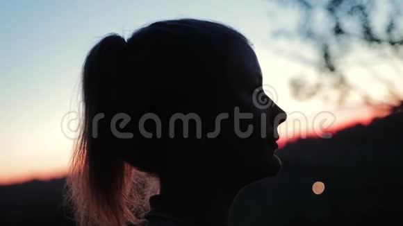 两个情人在高高的河岸上美丽的日落的背景下互相看着视频的预览图