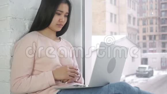 坐在窗边的美国黑人妇女在线视频聊天视频的预览图