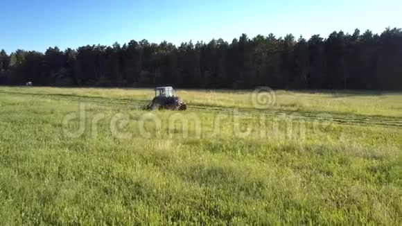 农夫驾驶拖拉机在田间割草视频的预览图