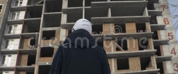白盔工程师用未完工的砖房观察施工现场视频的预览图
