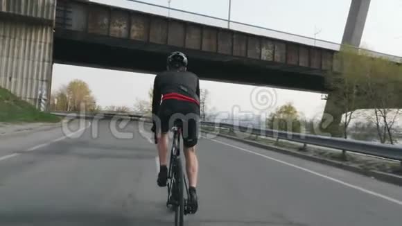 适合运动自行车骑自行车后面跟着射击年轻的自行车骑手骑自行车训练自行车的概念慢动作视频的预览图