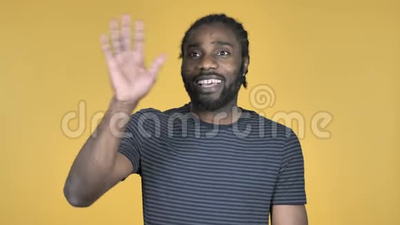 黄色背景下的非洲男子挥手欢迎视频的预览图