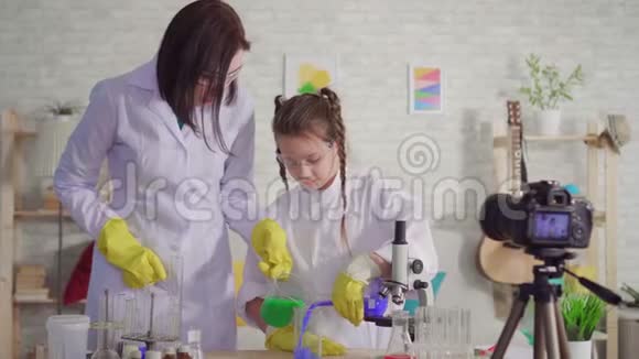女人和少女博主在化学实验室里混合试剂视频的预览图