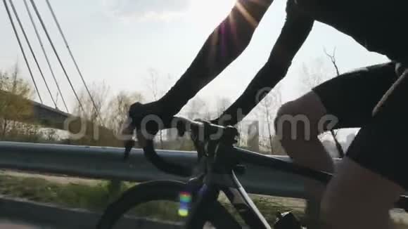 男子骑自行车和换挡阳光照耀背景上有桥关闭后续射击自行车的概念视频的预览图