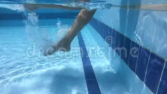 年轻女子的双腿在游泳池中不褪色慢慢地溅起水花视频的预览图