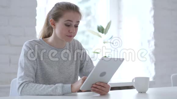 年轻女性在使用平板电脑时应对经济损失视频的预览图