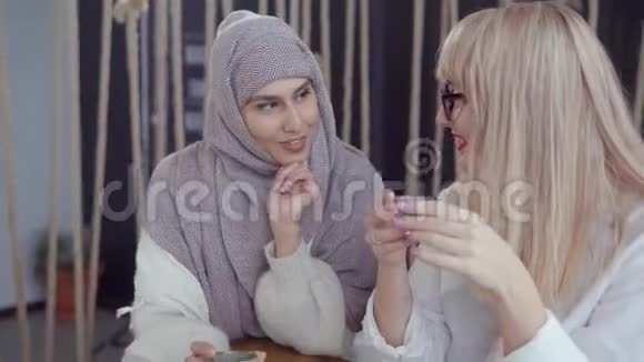 在喝茶的时候阿拉伯女人和她的金发女朋友秘密交谈视频的预览图
