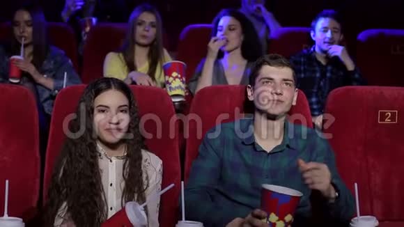 一个男人和一个女孩在电影院玩得很开心他们吃爆米花然后扔出去视频的预览图
