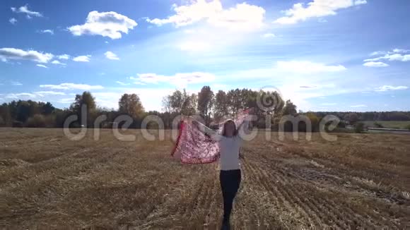 披着披肩的上半身女子站在田野的草包旁视频的预览图