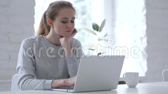 悲伤的年轻女子坐在办公室里视频的预览图
