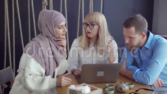 两个女人和一个男人正在房间里讨论看着电脑屏幕视频的预览图