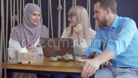 男人在咖啡馆里讲着有趣的故事他的两个女朋友一起笑视频的预览图