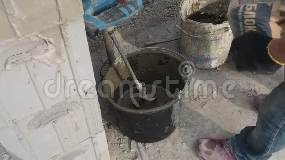 工人用搅拌机在桶中搅拌水泥砂浆视频的预览图