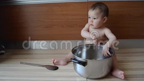 可爱的六个月大的小男孩在玩锅和木勺打哈欠视频的预览图