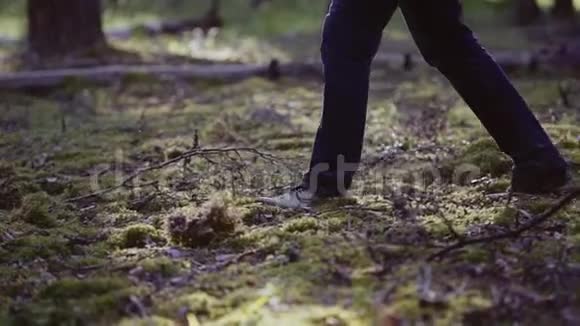 神秘的人手里拿着一把刀在树林里的地上可见他的脚在运动视频的预览图