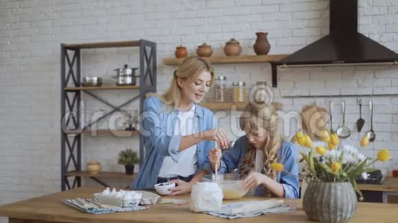 妈妈和女儿一起在厨房烤煎饼女孩帮她妈妈赚钱4k视频的预览图