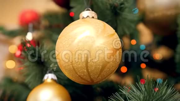 金色圣诞树枝在杉树枝上旋转的4k视频五颜六色的灯光闪烁着闪闪发光视频的预览图
