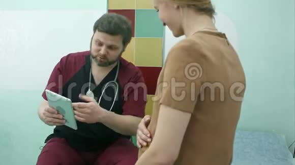 医生和孕妇一起看数字平板电脑视频的预览图