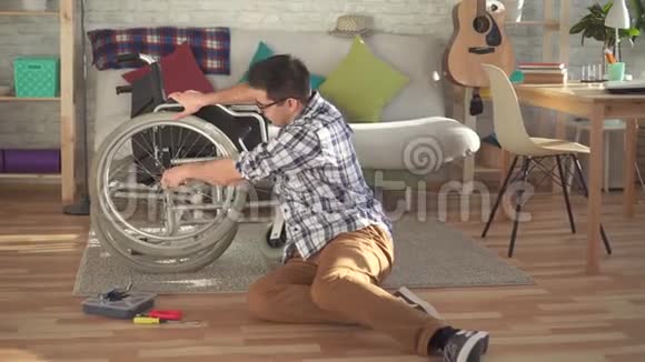 年轻的西班牙裔残疾人修理轮椅视频的预览图