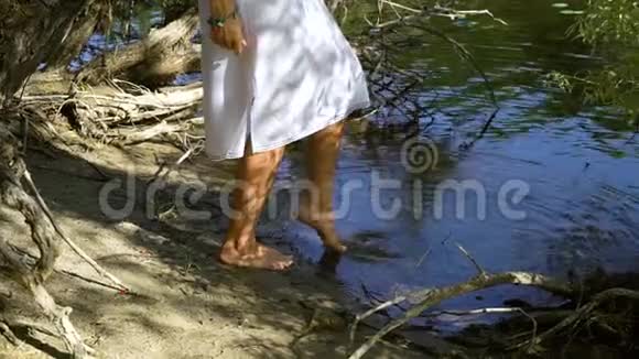 阳光明媚的日子里女人光着脚在河里游泳视频的预览图