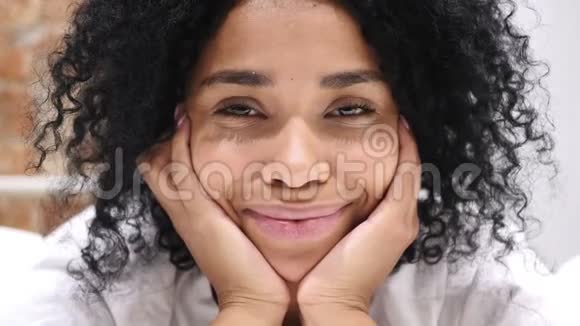 靠近微笑的美国黑人妇女躺在床上视频的预览图