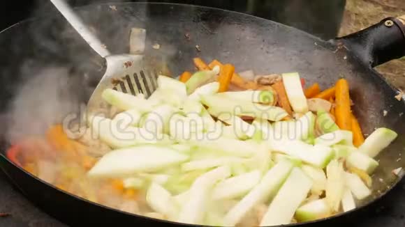 在户外用肉烹饪蔬菜在大锅里炒蔬菜假期康普特4千克视频的预览图