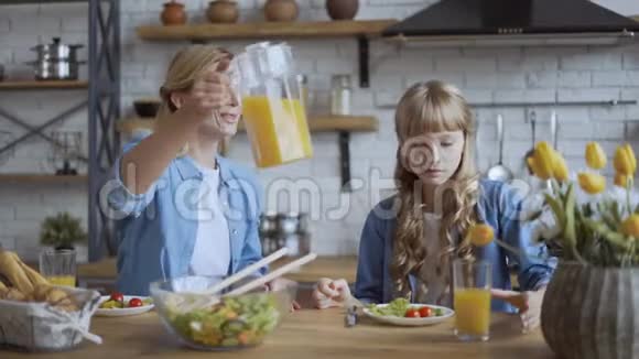 妈妈和女儿在午餐时吃健康的食物幸福家庭的概念4K视频的预览图
