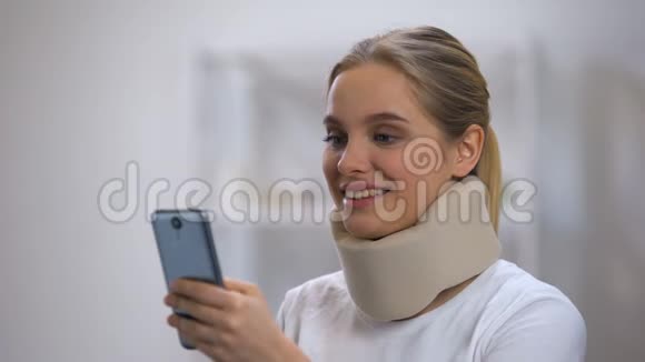 微笑女人在泡沫颈项圈阅读信息电话感觉颈部疼痛视频的预览图