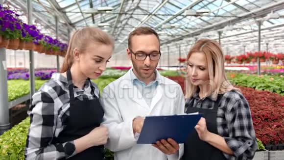 职业男性农业工程师与两位女性农民谈种植植物分析视频的预览图
