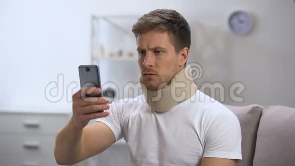 戴泡沫颈项圈的人在手机上看短信感觉脖子疼视频的预览图