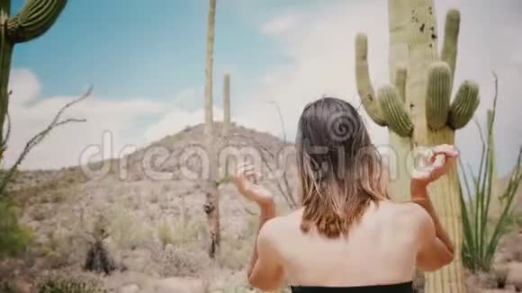 美国亚利桑那州的仙人掌沙漠国家公园里一位身穿黑色礼服的年轻当地女子正在散步视频的预览图