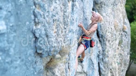 女子攀岩在艰难的运动路线上攀岩者艰难地移动和跌倒视频的预览图